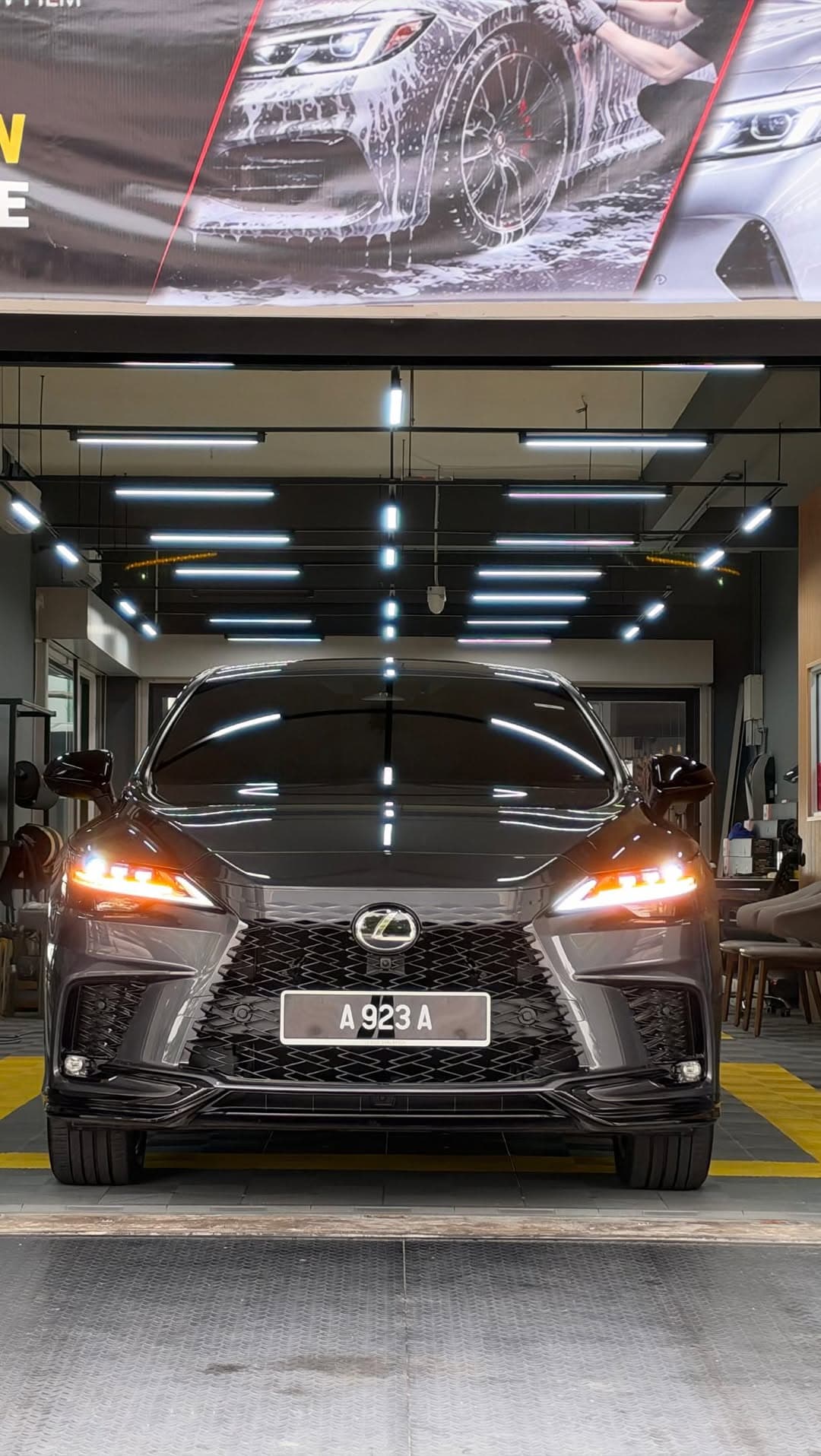 A grey Lexus RX under the lights in the ICAR detailing bay